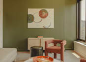 Thumbnail 17 of 36 - a living room with a chair and a painting on the wall at Scout Living, powered by Placemakr Apartments, Georgia