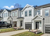 Thumbnail 2 of 36 - a row of white homes with a black car parked in front