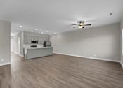 Thumbnail 3 of 36 - an empty living room with a ceiling fan and a kitchen