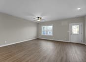 Thumbnail 5 of 36 - an empty living room with wood floors and a ceiling fan