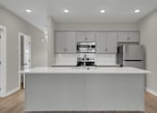 Thumbnail 6 of 36 - a kitchen with white cabinets and a white counter top