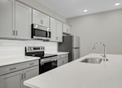 Thumbnail 8 of 36 - an empty kitchen with white counter tops and a sink