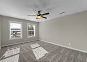 Thumbnail 10 of 36 - an empty living room with a ceiling fan and two windows