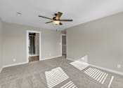 Thumbnail 11 of 36 - an empty living room with a ceiling fan and shadows on the floor