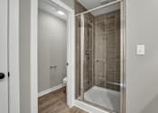 Thumbnail 13 of 36 - a bathroom with a shower and a toilet in it
