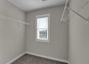Thumbnail 14 of 36 - an empty closet with two hanging racks and a window