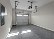 Thumbnail 19 of 36 - an empty garage with a white wall and a garage door