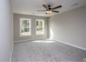 Thumbnail 28 of 36 - an empty living room with a ceiling fan and two windows