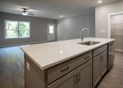 Thumbnail 23 of 36 - an empty kitchen with a large counter top and a sink