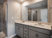 Thumbnail 27 of 36 - a bathroom with two sinks and a shower and a mirror