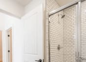 Thumbnail 6 of 19 - a bathroom with a white door and a shower with a glass door