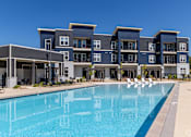 Thumbnail 39 of 39 - A large swimming pool is in front of a modern building.