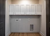 Thumbnail 33 of 39 - A kitchen with white cabinets and a trash can.