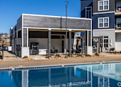 Thumbnail 12 of 39 - A modern house with a pool in front.