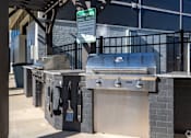 Thumbnail 24 of 39 - A sign that says "Community Grill Rules" hangs above a grill.