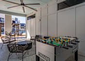 Thumbnail 25 of 39 - A foosball table is in the middle of a room with a ceiling fan.