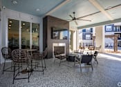 Thumbnail 14 of 39 - A patio with a fireplace and chairs.
