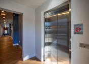 Thumbnail 19 of 39 - A stainless steel elevator with a red sign on the wall.