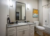 Thumbnail 27 of 39 - A bathroom with a white toilet, sink, and bathtub.