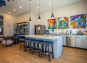Thumbnail 11 of 39 - A kitchen with a bar area and a refrigerator.
