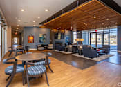 Thumbnail 10 of 39 - A large room with a wooden floor and a long table with chairs.