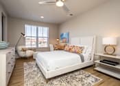 Thumbnail 29 of 39 - A bedroom with a white bed, a white dresser, and a white rug.
