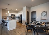 Thumbnail 23 of 39 - A modern kitchen with a dining table set for four.