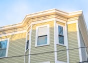 Thumbnail 6 of 14 - a house with green and yellow siding and white trim