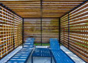 Thumbnail 21 of 23 - a covered patio with blue benches and tables