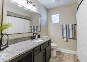 Thumbnail 17 of 23 - a bathroom with a toilet and a sink and a mirror