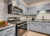 Thumbnail 5 of 23 - a kitchen with stainless steel appliances and white cabinets