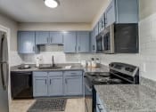 Thumbnail 6 of 23 - a kitchen with granite counter tops and blue cabinets