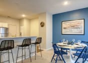 Thumbnail 2 of 42 - a dining area with a table and chairs and a kitchen in the background