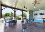 Thumbnail 12 of 14 - a patio with a fireplace and a bar with chairs and tables