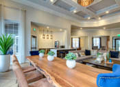 Thumbnail 9 of 42 - a living room with a long wooden table and blue chairs