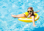 Thumbnail 27 of 42 - a girl in a swimming pool with a yellow float
