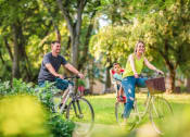 Thumbnail 33 of 42 - a man and woman riding bikes with a child on the back