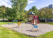 Thumbnail 34 of 42 - a park with a playground and a house in the background