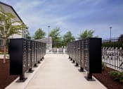 Thumbnail 40 of 47 - a row of mailboxes on a sidewalk with trees in the background