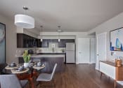 Thumbnail 17 of 47 - a dining area with a table and chairs and a kitchen in the background