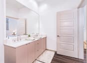 Thumbnail 7 of 25 - A bathroom with a white sink and a white door.
