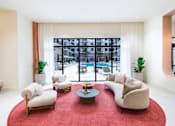 Thumbnail 13 of 25 - A living room with a red carpet and white furniture.