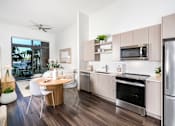 Thumbnail 2 of 25 - A modern kitchen with a dining table and chairs.