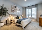 Thumbnail 3 of 23 - a bedroom with a large window and framed pictures on the wall
