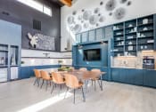 Thumbnail 9 of 23 - a kitchen with blue cabinets and a wooden table and chairs