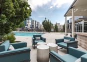 Thumbnail 19 of 23 - a swimming pool with blue chairs and a patio with tables