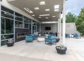 Thumbnail 23 of 23 - an outdoor patio with blue chairs and a fireplace