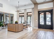 Thumbnail 18 of 41 - Leasing office with modern interior with a wooden reception desk and a black door. at Barton Creek Villas, Austin, 78735