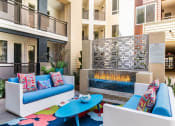 Thumbnail 13 of 27 - a patio with couches and a coffee table in front of an apartment building at Areum Apartment, Monrovia, 91016  