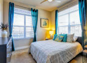 Thumbnail 2 of 25 - a bedroom with a bed and two windows